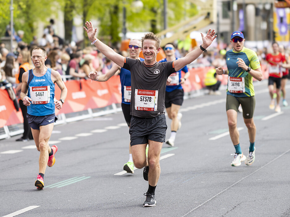 GENERALI BERLINER HALBMARATHON: Mann läuft jubelnd der Zielgerade entgegen © SCC EVENTS / Jean-Marc Wiesner