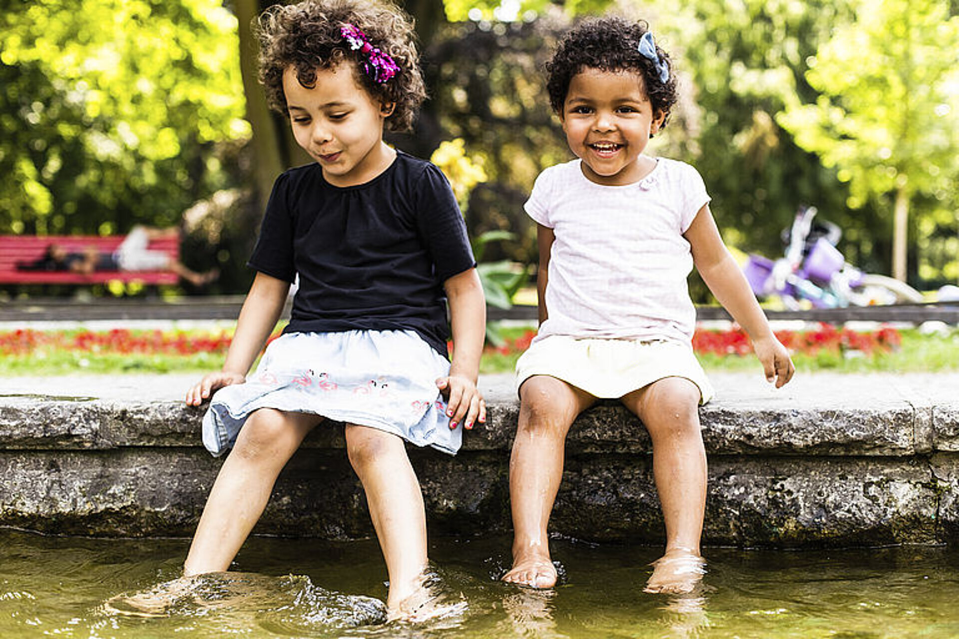 GENERALI BERLIN HALF MARATHON - The Human Safety Net: 2 little girls sitting at the edge of the river in a park © SCC Events