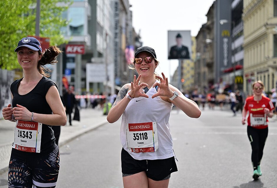 GENERALI BERLINER HALBMARATHON: weibliche Läuferin formt mit den Händen ein Herz und hält dieses in die Kamera © Petko Beier/ SCC EVENTS